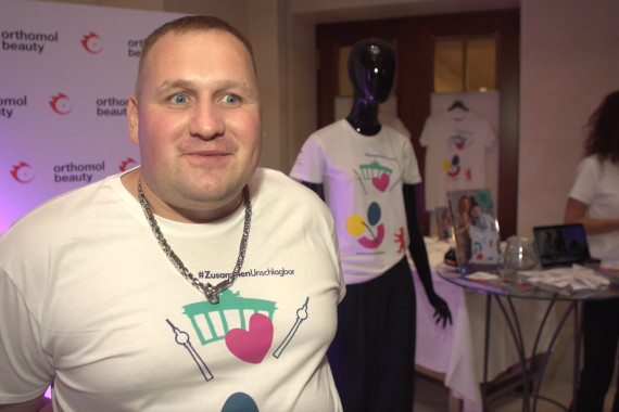 Dennis Mellentin, Athletensprecher der Special Olympics, hat das T-Shirt gemeinsam mit weiteren Athletinnen und Athleten designt. Auf der Fashion Show von Designerin Anja Gockel spricht er u.a. über die Teilnahme des Workshops.