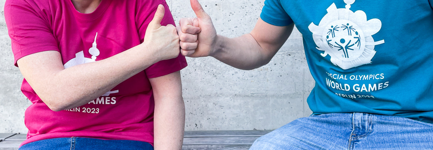 Athletin Daniela Huhn (l.) und Tobias Trollst (Organisationskomitee der Weltspiele 2023) haben sich im Webshop eingedeckt.