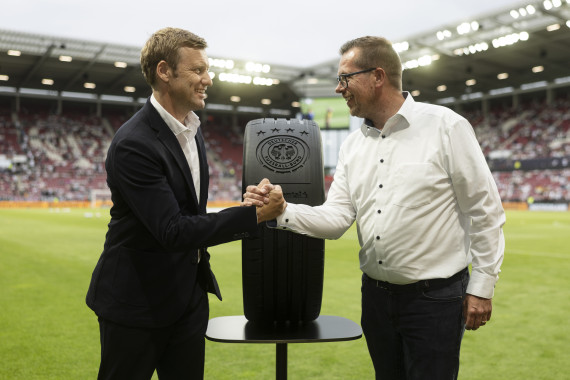 Timo Röbbel, Leiter Marketing Reifen-Ersatzgeschäft bei Continental, und Dr. Holger Blask, Vorsitzender der Geschäftsführung des DFB, besiegeln im Rahmen des Länderspiels Deutschland gegen Finnland am 31. Mai in Mainz die Verlängerung der Partnerschaft bis 2030.