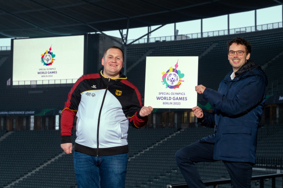 Dennis Mellentin (left), athletes spokesman Special Olympics Berlin, and Sven Albrecht, CEO LOC Special Olympics World Games Berlin 2023 and CEO Special Olympics Germany, present the logo in the Olympic Stadium in Berlin, opening ceremony venue in June 2023.